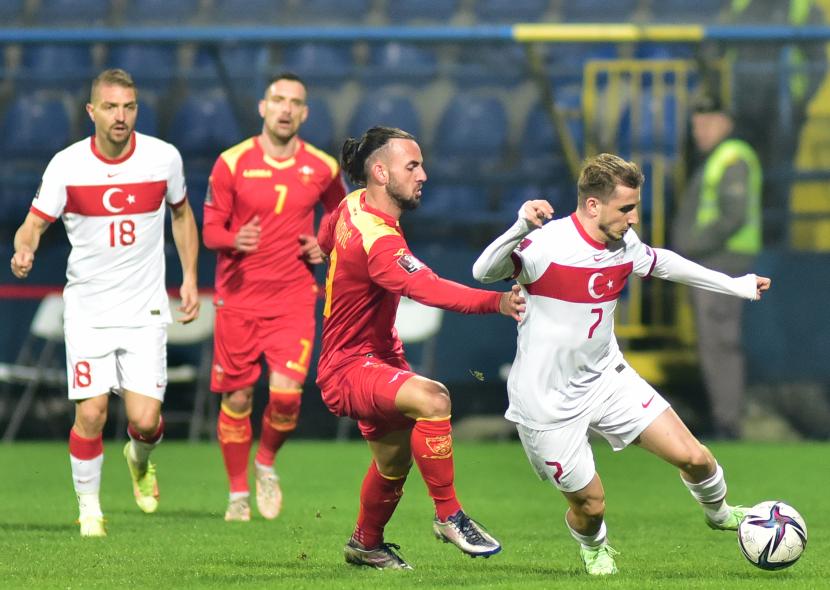 Kerem Akturkoglu (kanan) dari Turki beraksi melawan Marko Jankovic (kiri) dari Montenegro selama pertandingan sepak bola kualifikasi grup G Piala Dunia 2022 antara Montenegro dan Turki di Podgorica, Montenegro, Rabu (17/11).