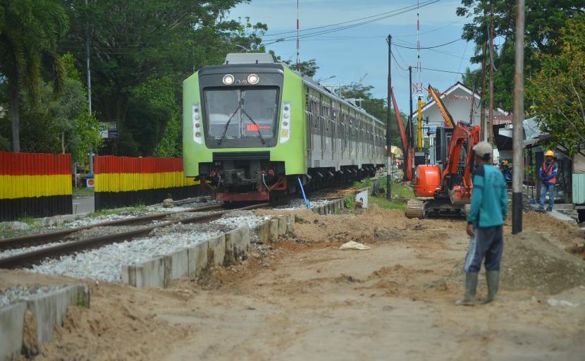 Kereta api melintas di samping pembangunan jalan kolektor perlintasan kereta api di Lubuk Buaya, Padang, Sumatra Barat, Sabtu (22/10/2022)