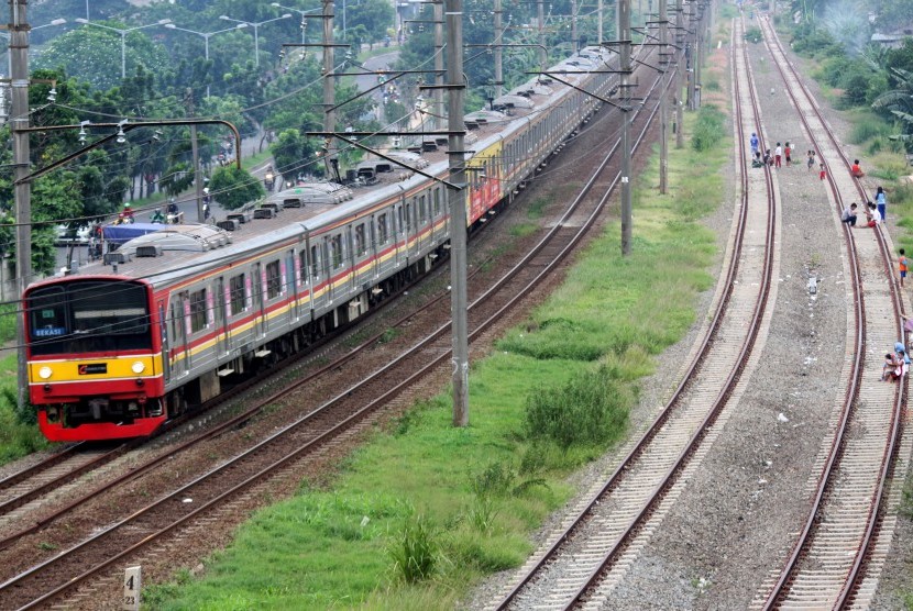 Kereta listrik melintas di samping jalur rel Double Double Track (DDT) yang sudah terpasang di kawasan Kalibaru, Bekasi, Jawa Barat, Jumat (11/3). 