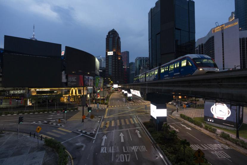Kereta melintasi pusat pertokoan Kuala Lumpur, Malaysia, Rabu (8/4). Pemerintah Malaysia memperpanjang pembatasan pergerakan dan perjalanan selama dua pekan ke depan atau hingga 28 April. 