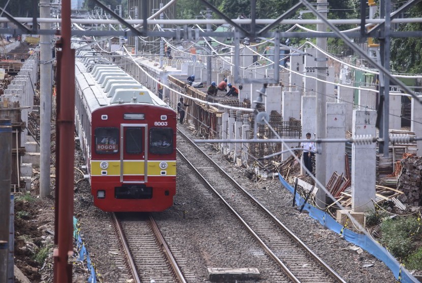 Kereta Rel Listrik (KRL) melaju di samping lokasi pembangunan Stasiun Sudirman Baru di Jakarta, Rabu (28/12). 