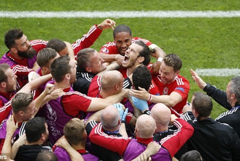 Kesebelasan Wales melakukan selebrasi usai sang bomber, Gareth Bale mencetak gol pembuka ke gawang Slovakia di laga perdana grup B Piala Eropa 2016, Sabtu (11/6) WIB.