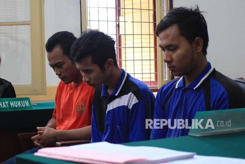 Ketiga terdakwa kasus pembunuhan sekeluarga Andi Lala (kiri), Andi Syahputra (tengah) dan Roni Anggara (kanan) mengikuti sidang dengan agenda tuntutan di Pengadilan Negeri Medan, Sumatera Utara, Jumat (29/12).