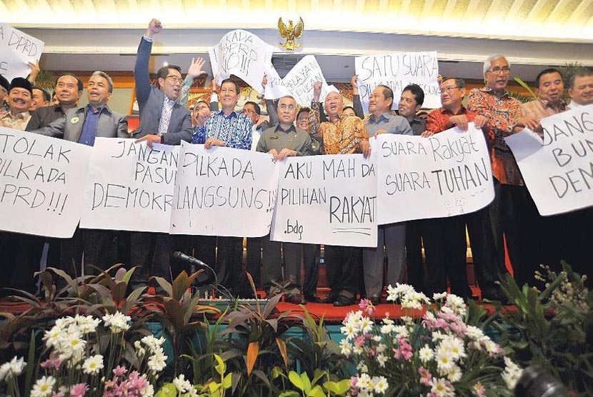 Ketua Asosiasi Pemerintah Kabupaten Seluruh Indonesia Isran Noor(tengah) dan Ketua Asosiasi Pemerintah Kota Seluruh Indonesia Vicky Lumentut(kelima kiri) bersama perwakilan bupati walikota menggelar poster seusai rapat koordinasi, di Jakarta,Kamis (11/9).