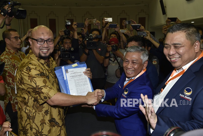 Ketua Bapilu Nasdem Effendy Choirie (kedua kanan) bersama Bendahara Umum Ahmad Ali (kanan) menyerahkan berkas pendaftaran bakal calon legislatif kepada anggota KPU Ilham Saputra (kedua kiri) dan Hasyim Asyari (kiri) di KPU Pusat, Jakarta, Senin (16/7). 