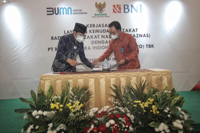 Ketua Baznas Prof. Dr. K.H.  Noor Ahmad M.A. (Kiri) dan Direktur Hubungan Kelembagaan BNI Sis Apik Wijayanto (Kanan) menandatangani Nota Kesepahaman tentang penciptaan kanal digitalisasi pengelolaan zakat di Jakarta, Rabu (5/5).