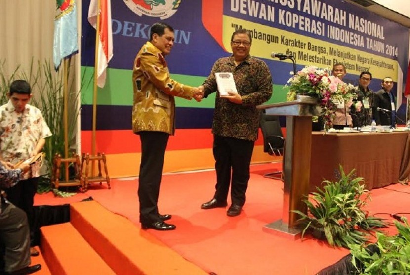 Ketua Dekopin Nurdin Halid (kiri) memberikan buku berjudul Koperasi Pilar Negara kepada Menteri Koperasi dan UKM AA Gede Ngurah Puspayofa