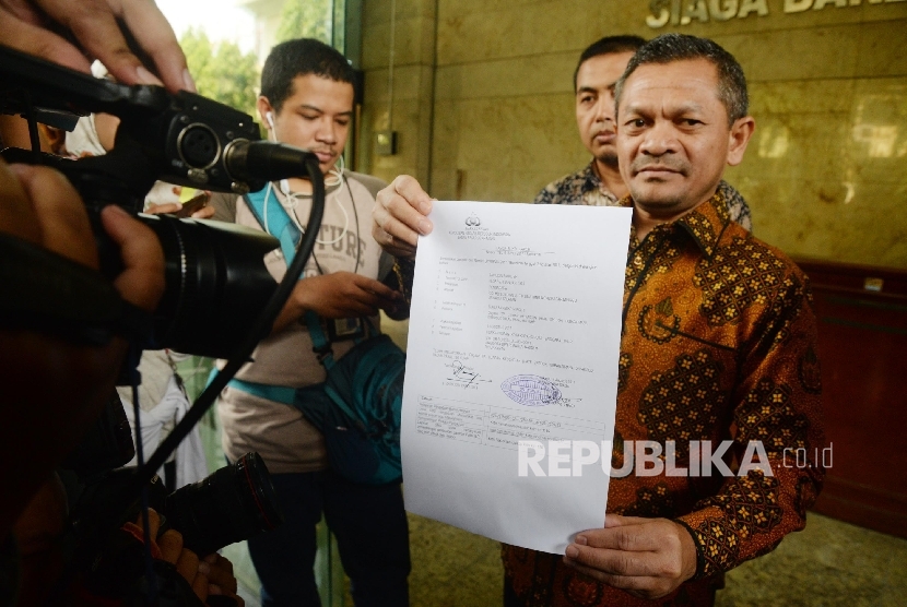 Ketua Departemen Hukum dan HAM DPP Partai Keadilan Sejahtera (PKS) Zainudin Paru menunjukkan surat pelaporan di Bareskrim Polri, Jakarta, Senin (7/8). 