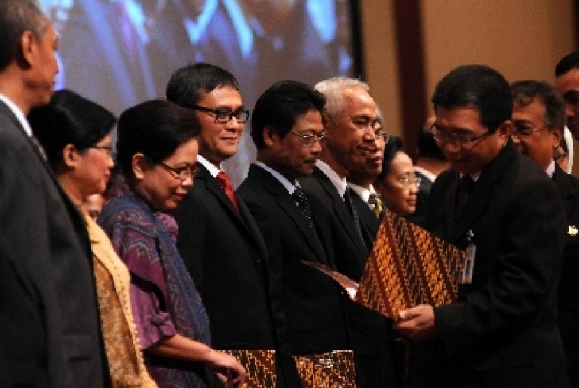 Ketua Dewan Komisioner OJK, Muliaman D Hadad (kanan) menyerahkan surat pengangkatan kepada pegawai OJK di Kementerian Keuangan, Jakarta, Rabu (5/12).