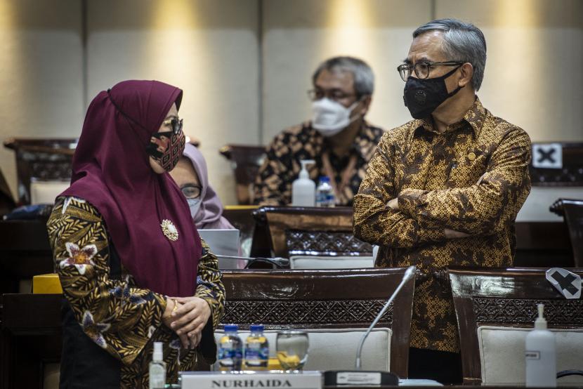 Ketua Dewan Komisioner Otoritas Jasa Keuangan (OJK) Wimboh Santoso (kanan) berbincang dengan Wakil Ketua Nurhaida sebelum dimulainya rapat kerja dengan Komisi XI DPR di Kompleks Parlemen, Senayan, Jakarta, Selasa (30/3/2021). 