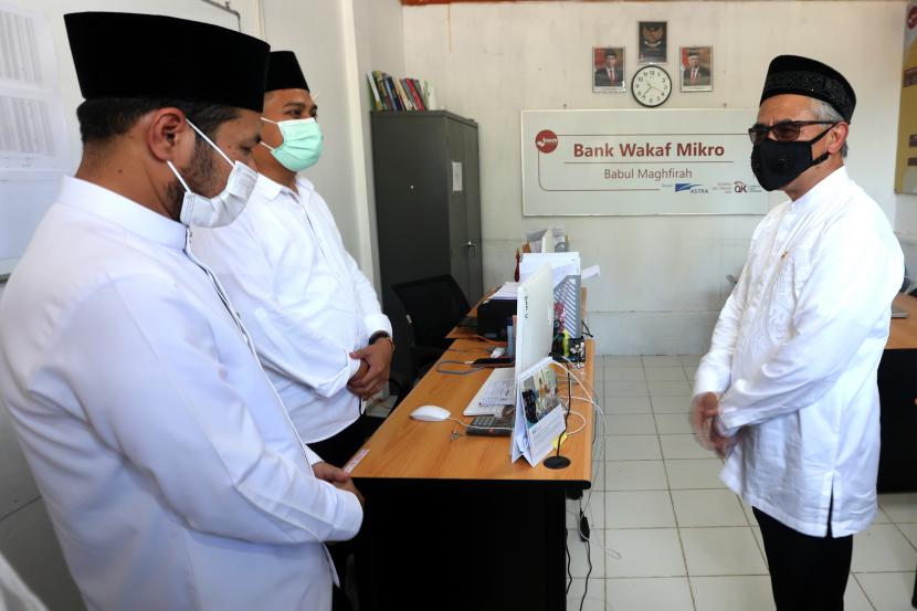 Ketua Dewan Komisioner Otoritas Jasa Keuangan (OJK) Wimboh Santoso (kanan) berbincang dengan pimpinan pondok pesantren Babul Magfirah Masrul Aidi (kiri) dan pengurus Bank Wakaf Mikro (BWM) pasantren binaan PT Astra Internasional TbK seusai diresmikan di Aceh Besar, Aceh, Jumat (8/4/2022). 