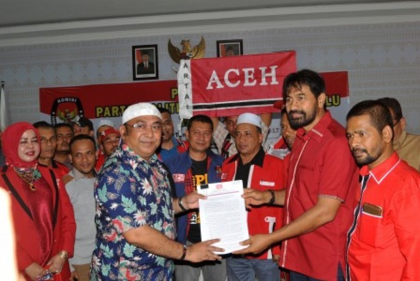 Ketua Dewan Pimpinan Aceh Partai Aceh Muzakir Manaf (kedua kanan) menyerahkan dokumen kepada Ketua Komisi Independen Pemilihan (KIP) Aceh Ridwan Hadi (kiri) pada hari terakhir pendaftaran Partai Politik Lokal Peserta Pemilu Tahun 2019 di Banda Aceh, Aceh, Senin (17/10).