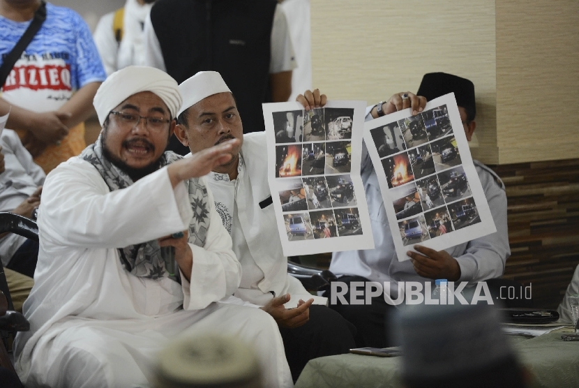 Ketua DPD FPI Jakarta Habib Muchsin Bin Zaid Al Athos (kiri) menunjukan foto pascakejadian terbakarnya mobil dalam kegiatan Isra Mi'raj saat menggelar konferensi pers di Masjid Al Ittihaat, Jakarta, Ahad (16/4). 