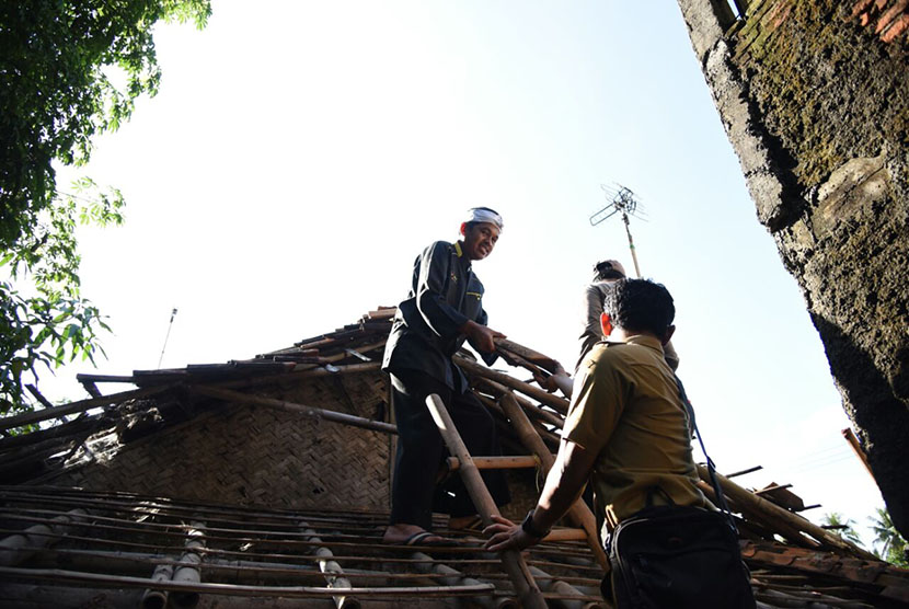 Ketua DPD Golkar Jabar, Dedi Mulyadi (ikat kepala) terjun langsung memperbaiki rumah penjaga kuburan.