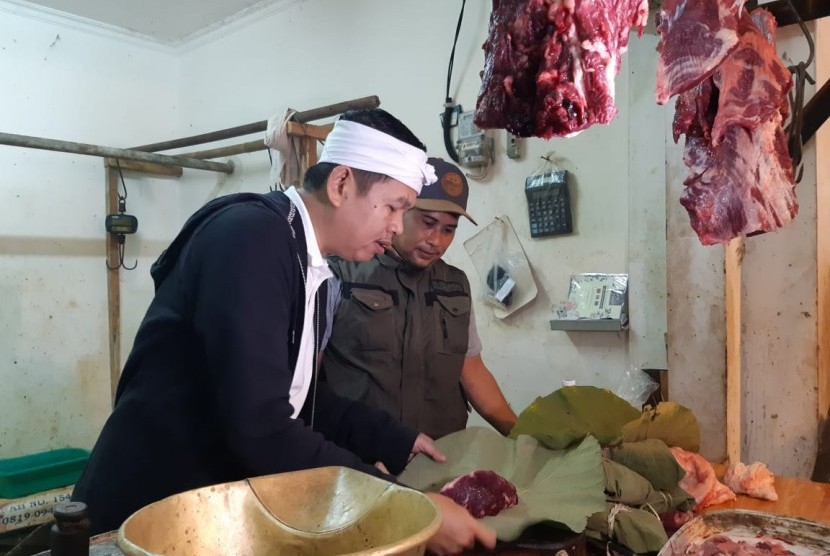 Ketua DPD Golkar Jabar yang juga mantan Bupati Purwakarta, Dedi Mulyadi, saat membeli daging sapi di Pasar Leuwi Panjang, dengan membawa sendiri daun jati dan ikat bambunya, Ahad (4/8).