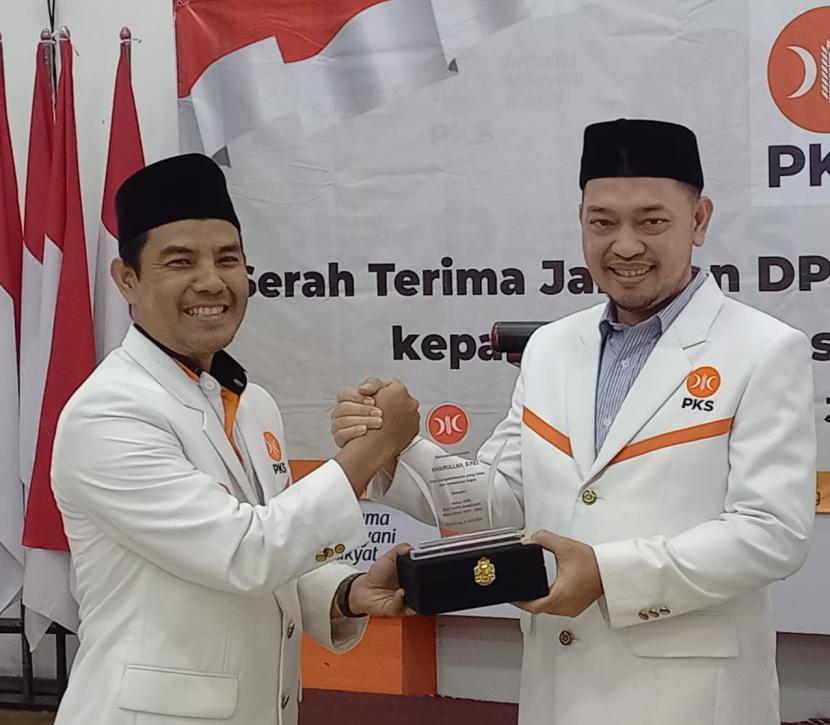 Ketua DPD PKS Kota Bandung Ahmad Rahmat Purnama (kiri) tengah berjabat tangan dengan ketua DPD PKS Kota Bandung sebelumnya Khairullah (Kanan). 