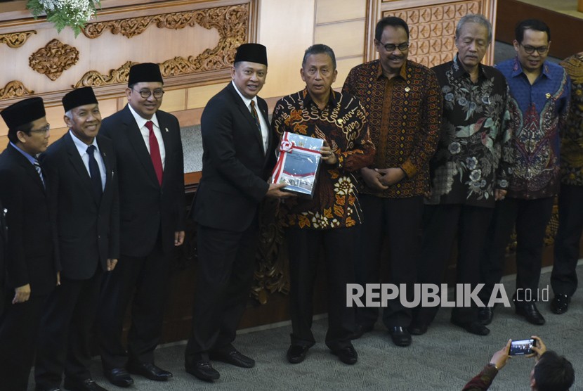 Ketua DPR Bambang Soesatyo (keempat kiri) berjabat tangan dengan Ketua BPK Moermahadi Soerja Djanegara (keempat kanan) saat menerima hasil laporan BPK pada Rapat Paripurna DPR di Kompleks Parlemen Senayan, Jakarta, Kamis (31/5).