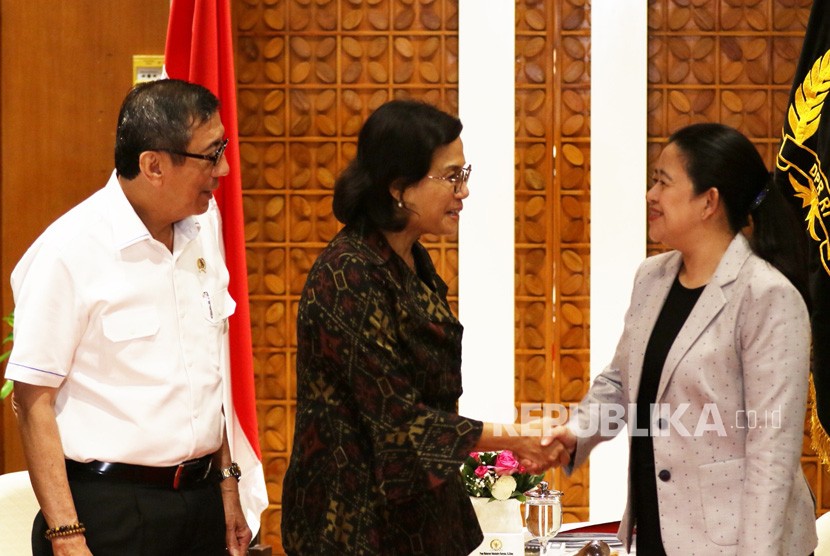 Ketua DPR Puan Maharani (kanan) berjabat tangan dengan Menteri Keuangan Sri Mulyani Indrawati (tengah) disaksikan Menteri Hukum dan HAM Yasonna Laoly, saat melakukan pertemuan di Kompleks Parlemen, Senayan, Jakarta, Kamis (30/1/2020).