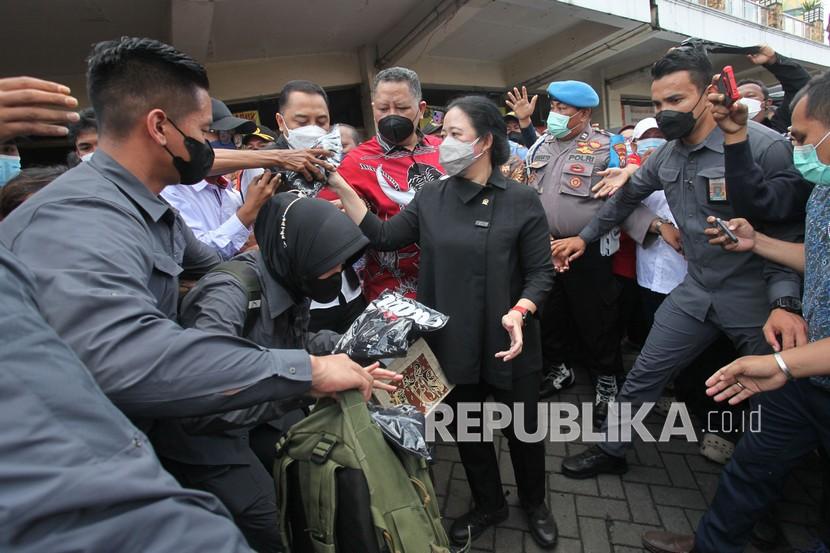 Ketua DPR Puan Maharani (tengah) membagikan kaos kepada warga saat meninjau Pasar Tambahrejo, Surabaya, Jawa Timur, Rabu (2/3/2022). Kunjungan kerja Ketua DPR di pasar itu untuk mengetahui secara langsung harga bahan pokok dan ketersediaannya. 