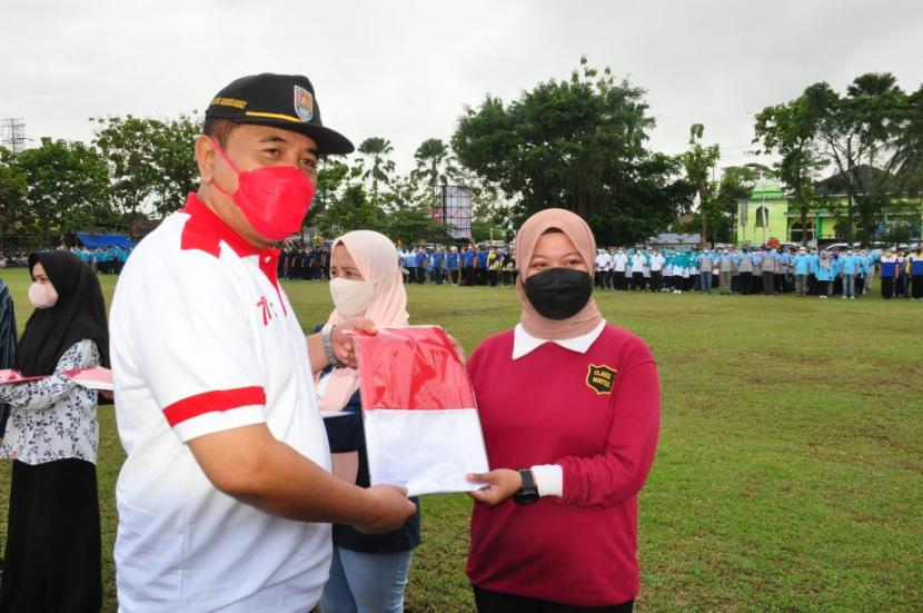 Ketua DPRD Cilacap, Taufik Nurhidayat menyerahkan bendera merah putih dalam rangka Gerakan Pengibaran 10 Juta Bendera Merah Putih Tingkat Kabupaten Cilacap. 