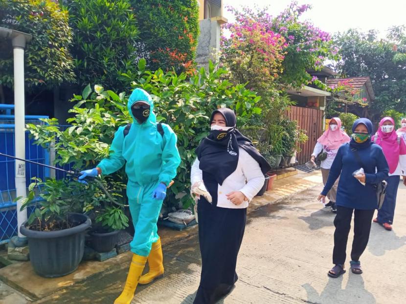 Ketua Empiris, Eis Rahmawati mendampingi petugas berbalut APD melakukan penyemprotan disinfektan di wilayah Duren Mekar, Bojongsari, Depok, Ahad (27/9).
