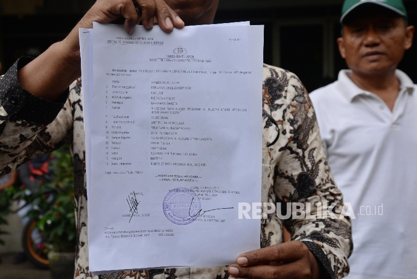 Ketua Forum Anti Penistaan Agama (FUPA) Syamsu Hilal Chaniago menunjukkan tanda bukti pelaporan Basuki Tjahaja Purnama atau Ahok terkait dugaan penistaan agama saat datang di SPKT Polda Metro Jaya, Jakarta. 