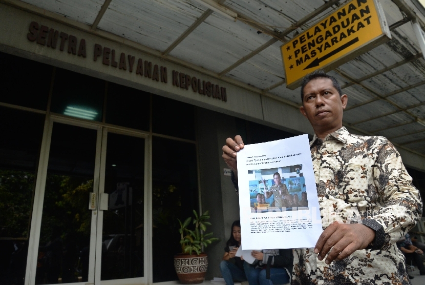 Ketua Forum Anti Penistaan Agama (FUPA) Syamsu Hilal Chaniago menunjukkan bukti gambar untuk melaporkan Basuki Tjahaja Purnama atau Ahok terkait dugaan penistaan agama saat datang di SPKT Polda Metro Jaya.