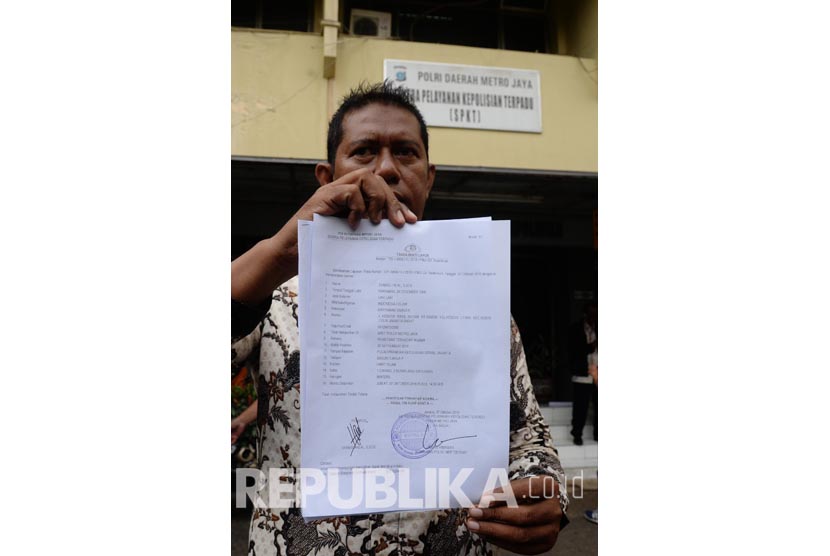 Ketua Forum Anti Penistaan Agama (FUPA) Syamsu Hilal Chaniago menunjukkan tanda bukti pelaporan Basuki Tjahaja Purnama atau Ahok terkait dugaan penistaan agama saat datang di SPKT Polda Metro Jaya, Jakarta, Jumat (7/10). 