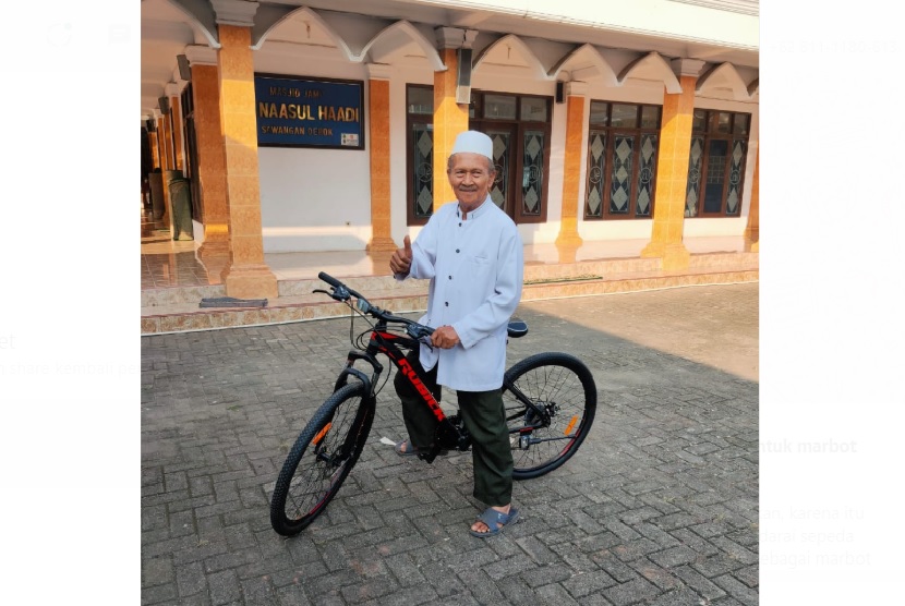 Ketua GWS MTB Depok memberikan sepeda kepada marbot Masjid Annasul Haadi Sawangan Hasan Basri