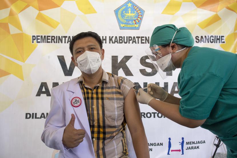 Ketua Ikatan Dokter Indonesia Cabang Sangihe Aprikonus Daud Loris (kiri) menerima suntikan vaksin COVID-19 Sinovac di Rumah Sakit Liun Kendage Tahuna, Sulawesi Utara, Senin (1/2/2021). Vaksinasi untuk mencegah COVID-19 di Kepulauan Sangihe tersebut merupakan tahap pertama.