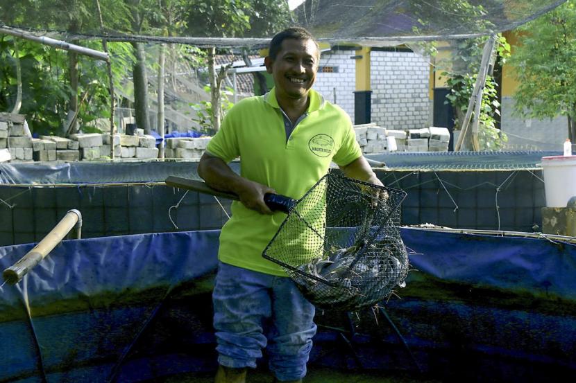 Ketua kelompok budidaya ikan Prima Makmur, Desa Jenggolo, Kecamatan Jenu, Kabupaten Tuban, Liek Setiadji memperlihatkan ikan lele hasil budidaya kelompoknya, baru- baru ini. Program kemandirian dan pengembangan usaha oleh PT Semen Indonesia (Persero) Tbk/ (SIG) telah mendorong peningkatan produksi kelompok UMKM budidaya ikan tersebut.