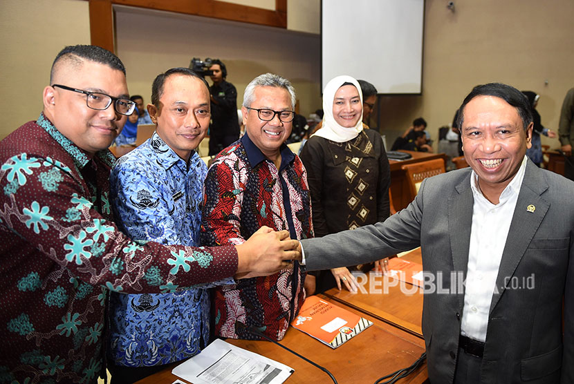 Ketua Komisi II DPR Zainudin Amali (kanan) berjabat tangan dengan Ketua KPU Arief Budiman (tengah), Dirjen Dukcapil Kemendagri Zudan Arif Fakrulloh (kedua kiri), Anggota Bawaslu Fritz Edward Siregar (kiri) dan Anggota KPU Evi Novida Ginting Manik (kedua kanan) sebelum mengikuti rapat di Kompleks Parlemen, Senayan, Jakarta, Senin (21/5). 