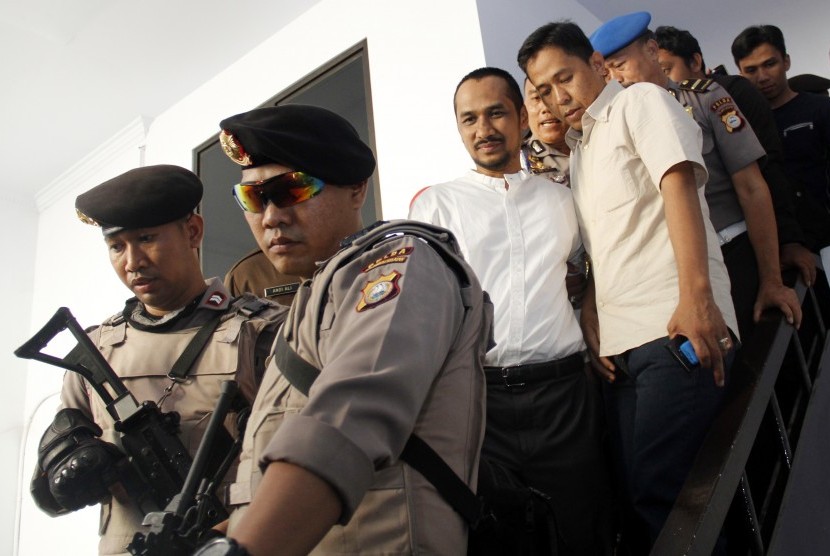 Ketua Komisi Pemberantasan Korupsi (KPK) nonaktif Abraham Samad (tengah) dikawal polisi seusai menjalani pemeriksaan di Kejaksaan Negeri Makassar, Sulawesi Selatan, Selasa (22/9).