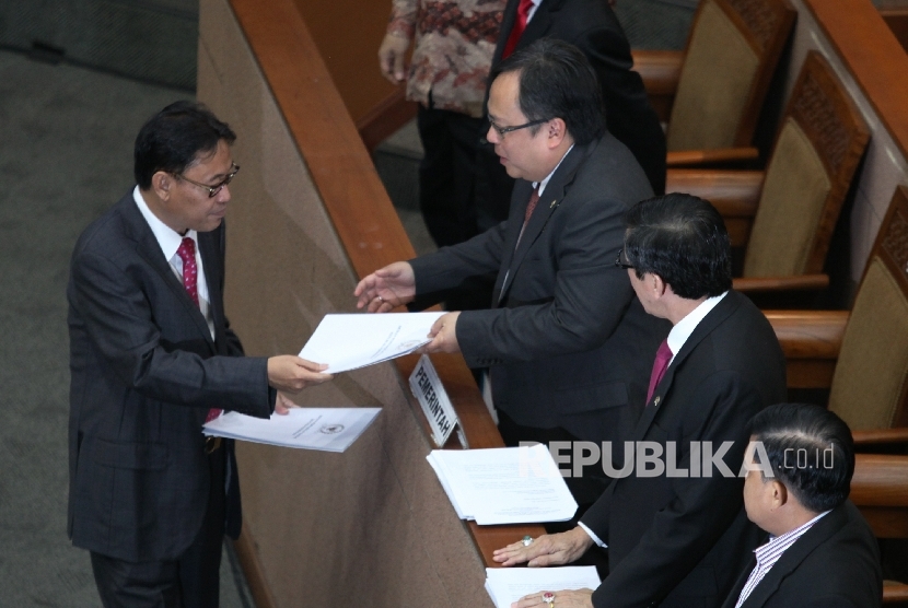 Ketua Komisi XI Ahmadi Noor Supit menyerahkan laporan hasil pembahasan RUU Pengampunan Pajak (Tax Amnesty) kepada Menkeu Bambang Brodjonegoro(kedua kiri) dan Menkum HAM Yasonna Laoly (kedua kanan) pada rapat Paripurna DPR di Kompleks Parlemen,Jakarta.