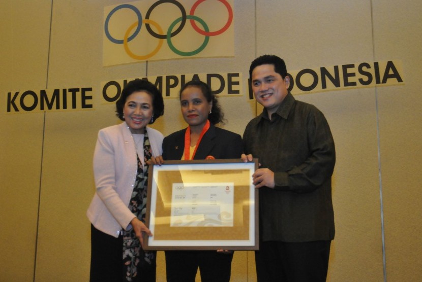 Ketua Komite Olimpiade Indonesia (KOI) Erick Thohir (kanan) dan Anggota Senior IOC Rita Soebowo (kiri) memberikan medali/penghargaan kepada atlet angkat besi Lisa Rumbewas di sela-sela Rapat Koordinasi Akhir Tahun 2017 KOI di Jakarta, Ahad (3/12) malam. Pada acara tersebut juga disampaikan rencana KOI dalam mempersiapkan tim Indonesia baik untuk test event maupun saat perhelatan Asian Games 2018.   