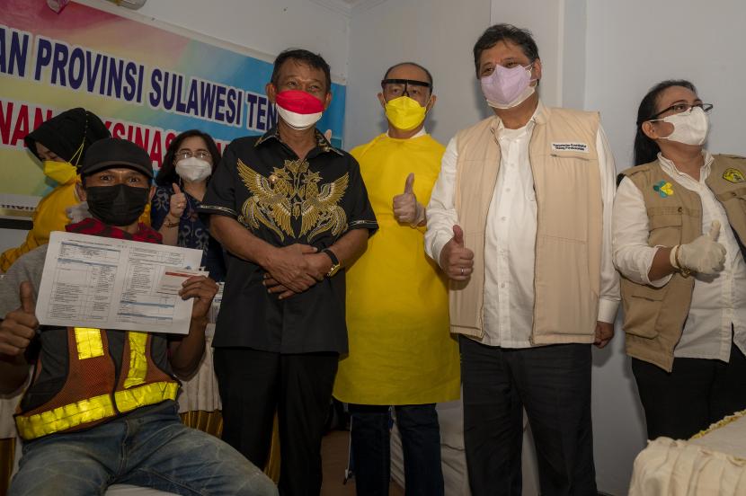 Ketua Komite Penanganan COVID-19 dan Pemulihan Ekonomi Nasional (KPCPEN) Airlangga Hartarto (kedua kanan) bersama Gubernur Sulteng Rusdy Mastura (ketiga kiri) berfoto dengan petugas medis dan warga saat meninjau pelaksanaan vaksinasi di Kantor Gubernur Sulteng di Palu, Sulawesi Tengah, Jumat (27/8/2021). Airlangga Hartarto menekankan pentingnya perluasan dan percepatan pelaksanaan vaksinasi COVID-19 di Sulteng yang baru mencapai 17,48 persen dari target 2,1 juta jiwa agar tercipta kekebalan komunitas.