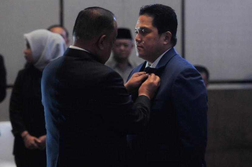 Ketua KONI Pusat Marciano Norman (kiri) menyematkan pin kepada Ketua Umum PSSI Erick Thohir (kanan) saat Pengukuhan dan Pelantikan Pengurus PSSI di Jakarta, Jumat (26/5/2023).