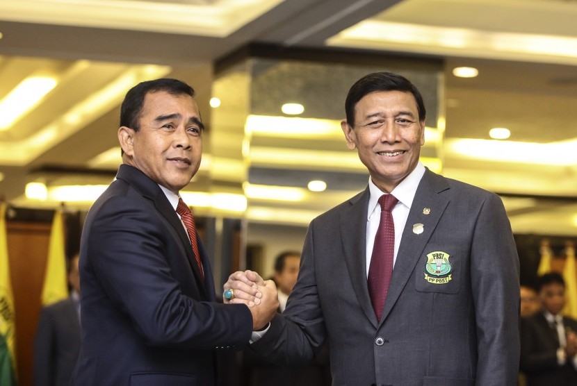 Ketua KONI Pusat Tono Suratman (kiri) berjabat tangan dengan Ketua Umum PP PBSI Wiranto (kanan) pada upacara pelantikan pengurus PP PBSI Masa bakti 2016-2020 di Jakarta, Kamis (19/1).