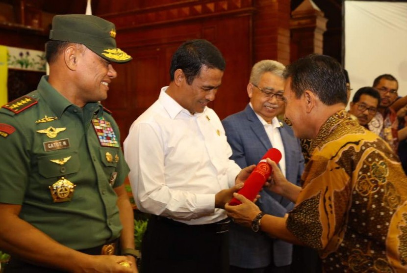 Ketua Kontak Tani Nelayan Andalan (KTNA) Indonesia Winarno Tohir (kanan) memberikan penghargaan kepada Menteri Pertanian Andi Amran Sulaiman di Banda Aceh, Jumat (5/5).
