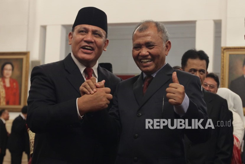 Ketua KPK periode 2015-2019 Agus Rahardjo (kanan) memberikan ucapan selamat kepada Ketua KPK periode 2019-2023 Firli Bahuri seusai acara pelantikan di Istana Negara, Jakarta, Jumat (20/12).
