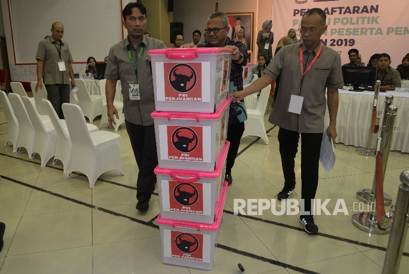 Ketua KPU Arief Budiman bersama petugas menata boks kontainer berisi berkas dan syarat pendaftaran partai PDI-P di kantor KPU Pusat, Jakarta, Rabu (11/10).
