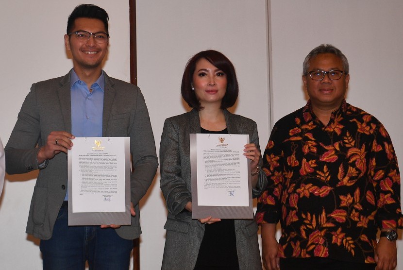 Ketua KPU Arief Budiman (kanan) mendampingi moderator debat Zulfikar Naghi (kiri) dan Retno Pinasti menunjukkan pakta integritas debat keempat calon Presiden Pemilu 2019 di Jakarta, Rabu (27/3/2019).