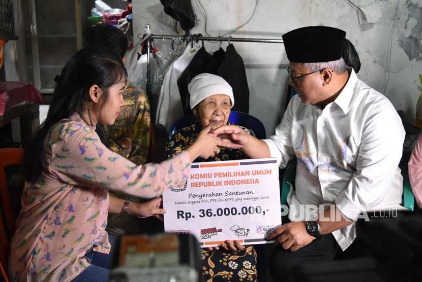 Ketua KPU Arief Budiman (kanan) menyerahkan santunan kepada keluarga almarhum Tutung Suryadi, petugas KPPS yang wafat, di Tangki, Tamansari, Jakarta Barat, Jumat (3/5/2019). 