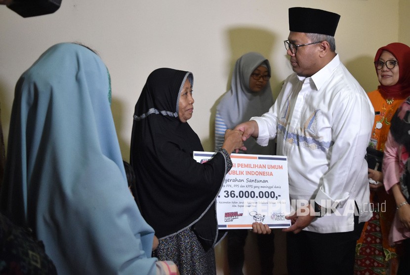 Ketua KPU Arief Budiman (kedua kanan) menyerahkan santunan uang kepada keluarga almarhum Umar Madi, petugas KPPS yang wafat, di kelurahan Sukabumi Selatan, Kebon Jeruk, Jakarta Barat, Jumat (3/5/2019). 