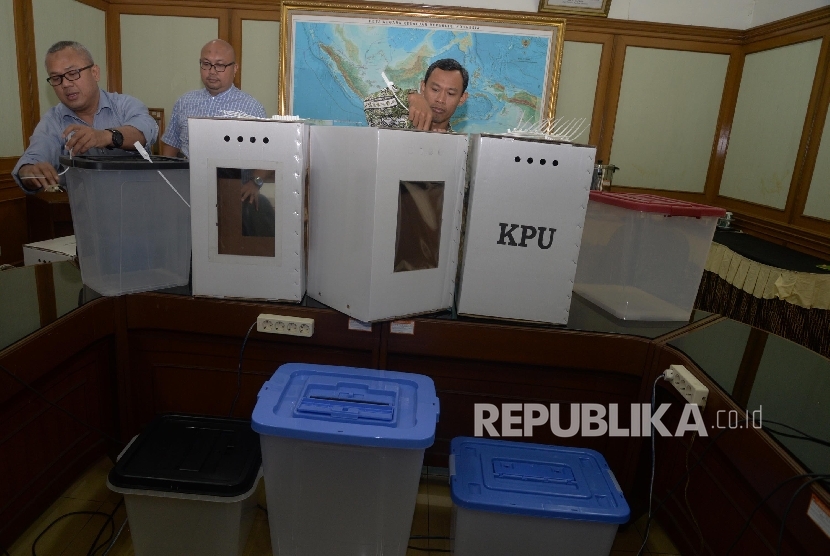 Ketua KPU Arief Budiman (kiri), bersama anggota KPU Pramono Ubaid Tanthowi (kanan), dan Ilham Saputra (tengah) menunjukkan contoh alternatif bentuk kotak suara transparan terbuat dari kertas karton dan Box plastik akan digunakan dalam Pilkada serentak 2018 dan Pemilu 2019 di kantor KPU, Jakarta, Senin (7/8).