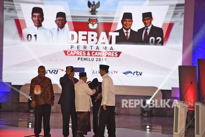 Ketua KPU Arief Budiman (kiri) bersama pasangan capres-cawapres nomor urut 01 Joko Widodo (kanan) dan Ma'ruf Amin (ketiga kanan) serta pasangan nomor urut 02 Prabowo Subianto (kedua kiri) dan Sandiaga Uno (kedua kanan) bersiap mengikuti debat pertama Pilpres 2019, di Hotel Bidakara, Jakarta, Kamis (17/1/2019). 