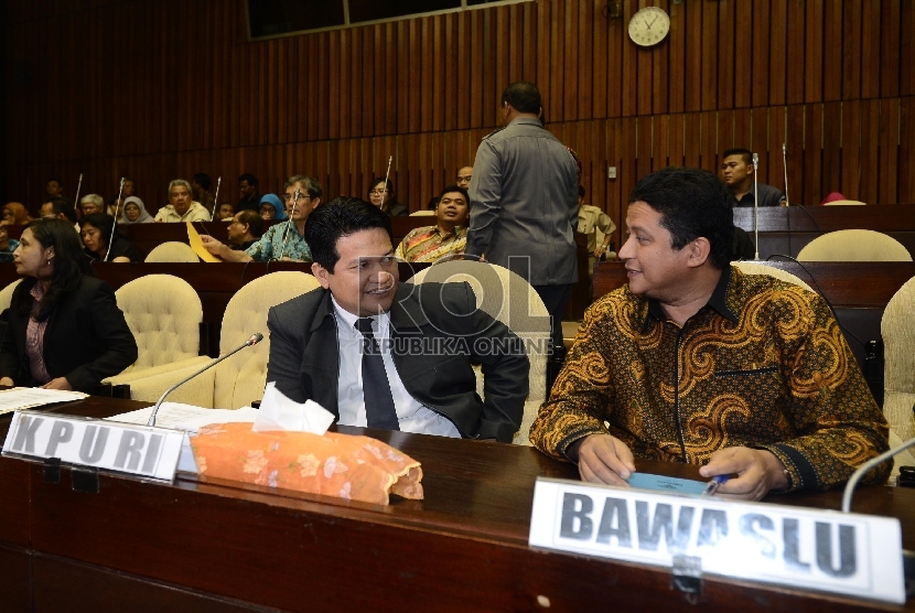 Ketua KPU, Husni Kamil Manik (kiri) berbincang bersama Ketua Bawaslu, Muhammad (kedua kiri) saat rapat dengar pendapat di Komisi II, DPR RI, Jakarta, Senin (22/6). 