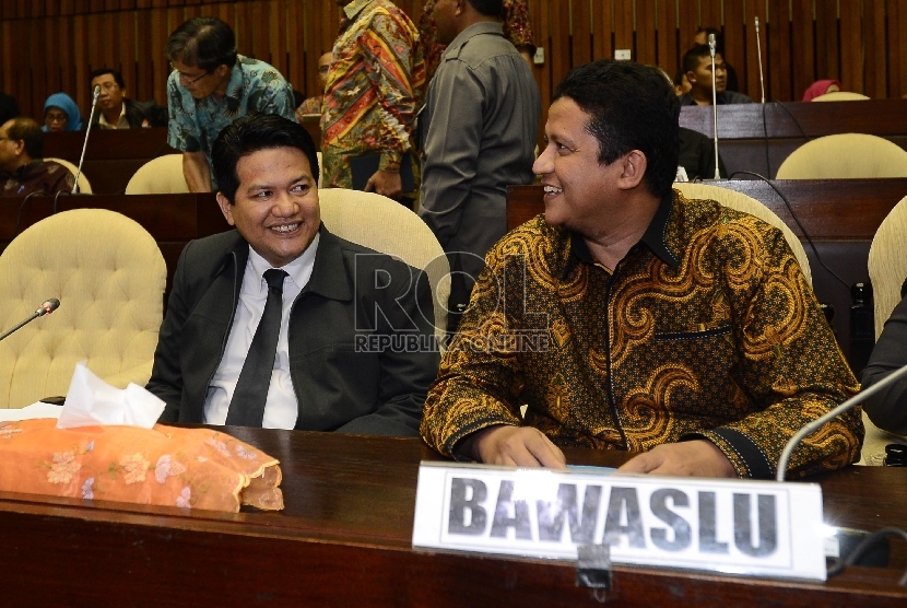 Ketua KPU, Husni Kamil Manik (kiri) berbincang bersama Ketua Bawaslu, Muhammad (kedua kiri) saat rapat dengar pendapat di Komisi II, DPR RI, Jakarta, Senin (22/6). 