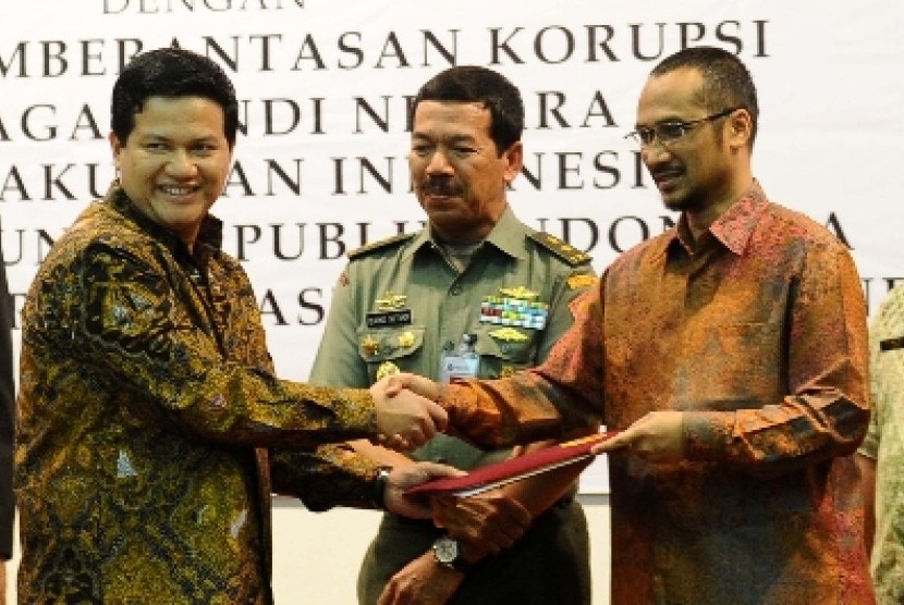 Ketua KPU Husni Kamil Manik (kiri), Ketua KPK Abraham Samad (kanan) dan Kepala Lembaga Sandi Negara Djoko Setiadi (tengah) bertukar draft penandatanganan kerjasama di Jakarta, Selasa (24/9).
