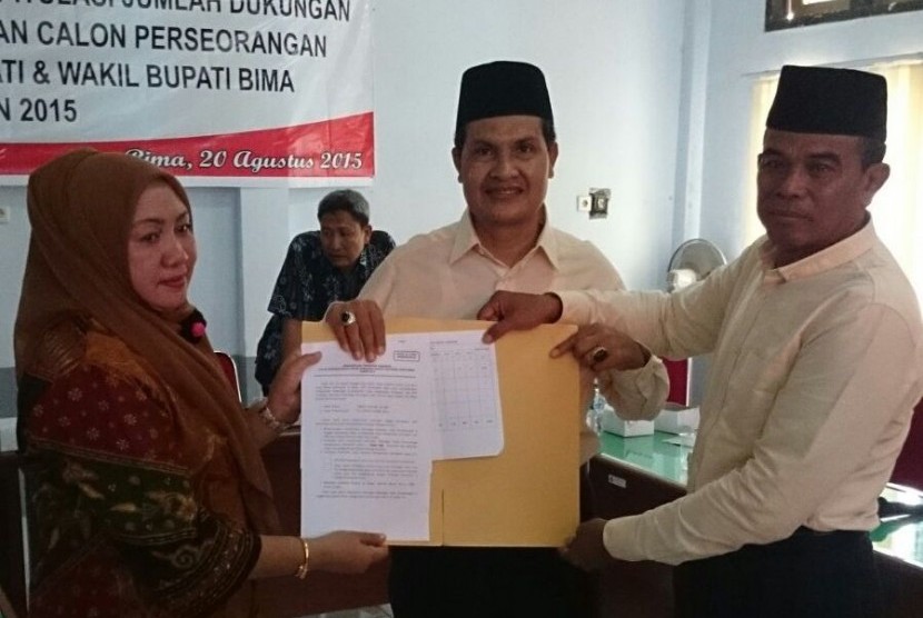 Ketua KPU Kabupaten Bima Nursusila (kiri) menyerahkan berita acara pemeriksaan verfikasi faktual dukungan KTP ke pasangan calon independen bupati Bima Abdul Khayir (tengah) dan calon wakil bupati Bima Abdul Hamid di Kantor KPU Bima, Kamis (20/8)  